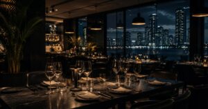 Dining room at night with the Miami skyline beyond the windows. Hospitality, GCC Media.